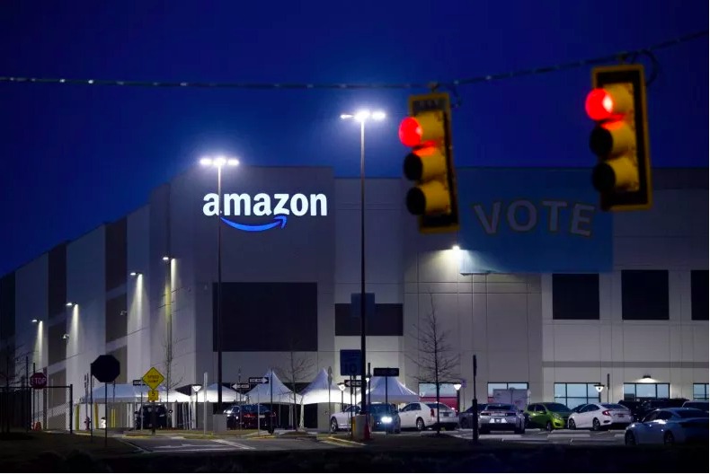 A pro-union banner hangs at a stoplight outside an Amazon Fulfillment Center.