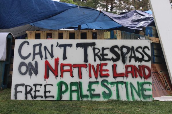 A sign criticizing UNMs attempts at clearing the encampment and charging students with trespassing.